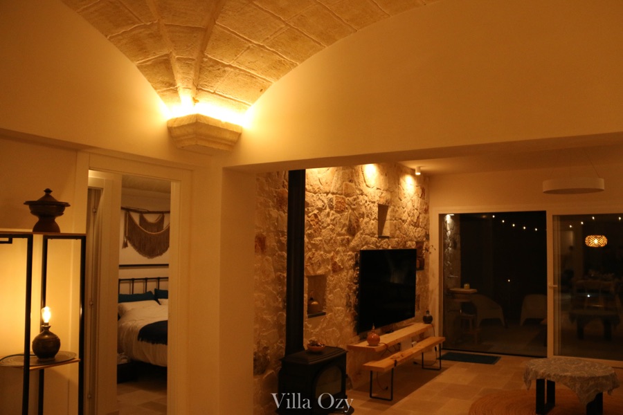 Stone vault and feature wall lit by warm wall sconces in the evening