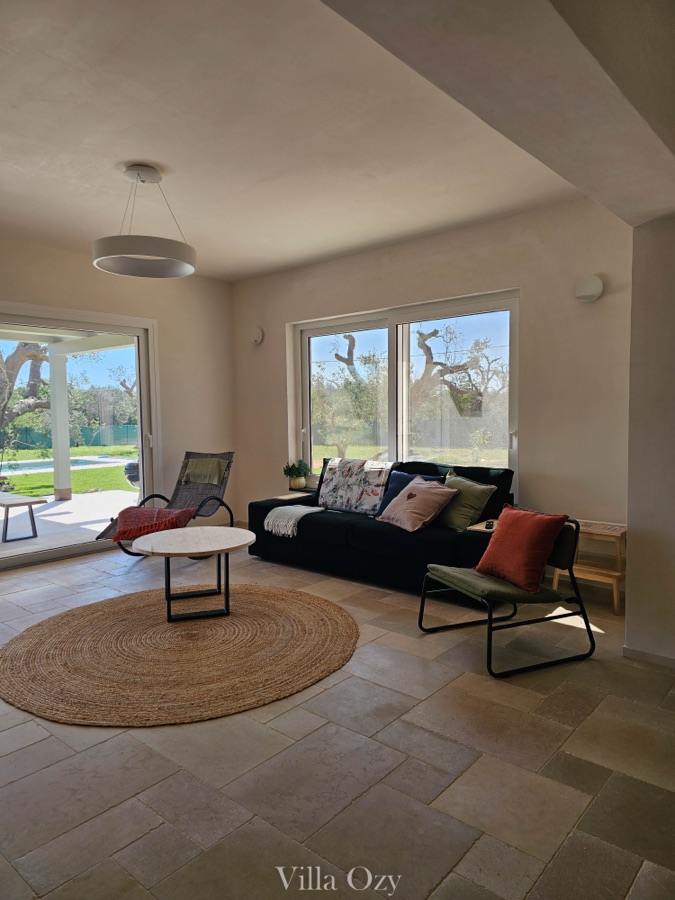 Sitting room with deep sofa, two armchairs and a round jute rug